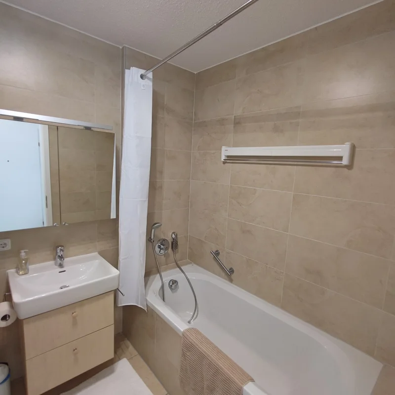 Badezimmer mit Badewanne und Duschvorhang