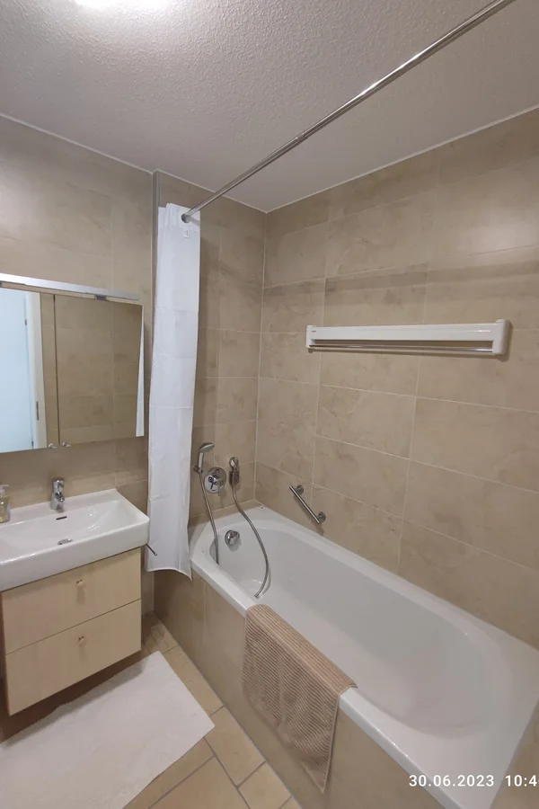 Badezimmer mit Badewanne und Duschvorhang