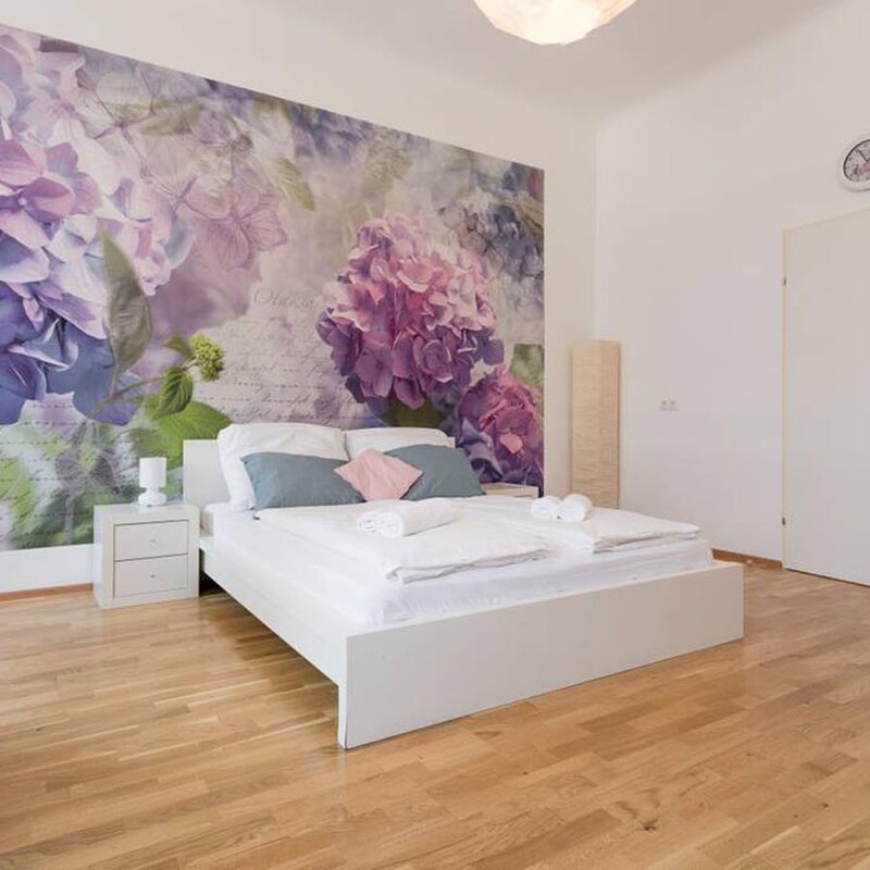 Helles Schlafzimmer mit floralem Wandbild – 3-Zimmer Wohnung zur Kurzzeitmiete & Wohnen auf Zeit für 1 bis 6 Monate in Wien