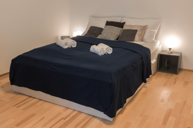 Gepflegtes Schlafzimmer mit Doppelbett & Nachttischlampen – 1-Zimmer Apartment zur Kurzzeitmiete in Wien