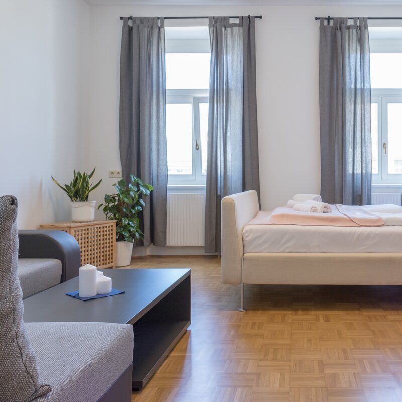 Helles Wohnschlafzimmer mit Doppelbett & Sofa – 3-Zimmer-Wohnung zur Kurzzeitmiete & Wohnen auf Zeit für 1 bis 6 Monate in Wien