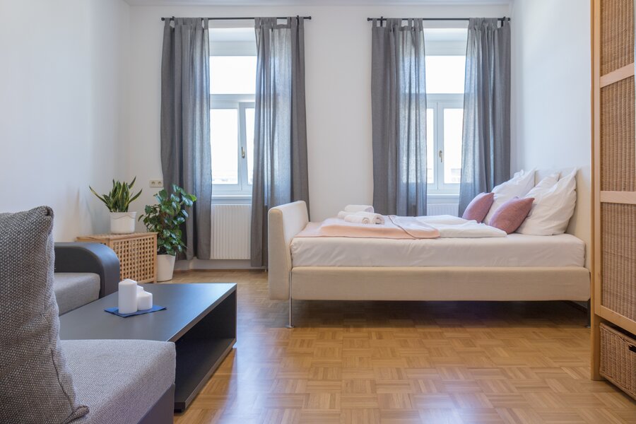 Helles Wohnschlafzimmer mit Doppelbett & Sofa – 3-Zimmer-Wohnung zur Kurzzeitmiete & Wohnen auf Zeit für 1 bis 6 Monate in Wien