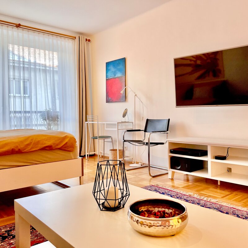 Gemeinsamer Wohn-/Schlafraum mit Flatscreen und kleinem Arbeitsplatz und gemütlicher Couch. | © rb