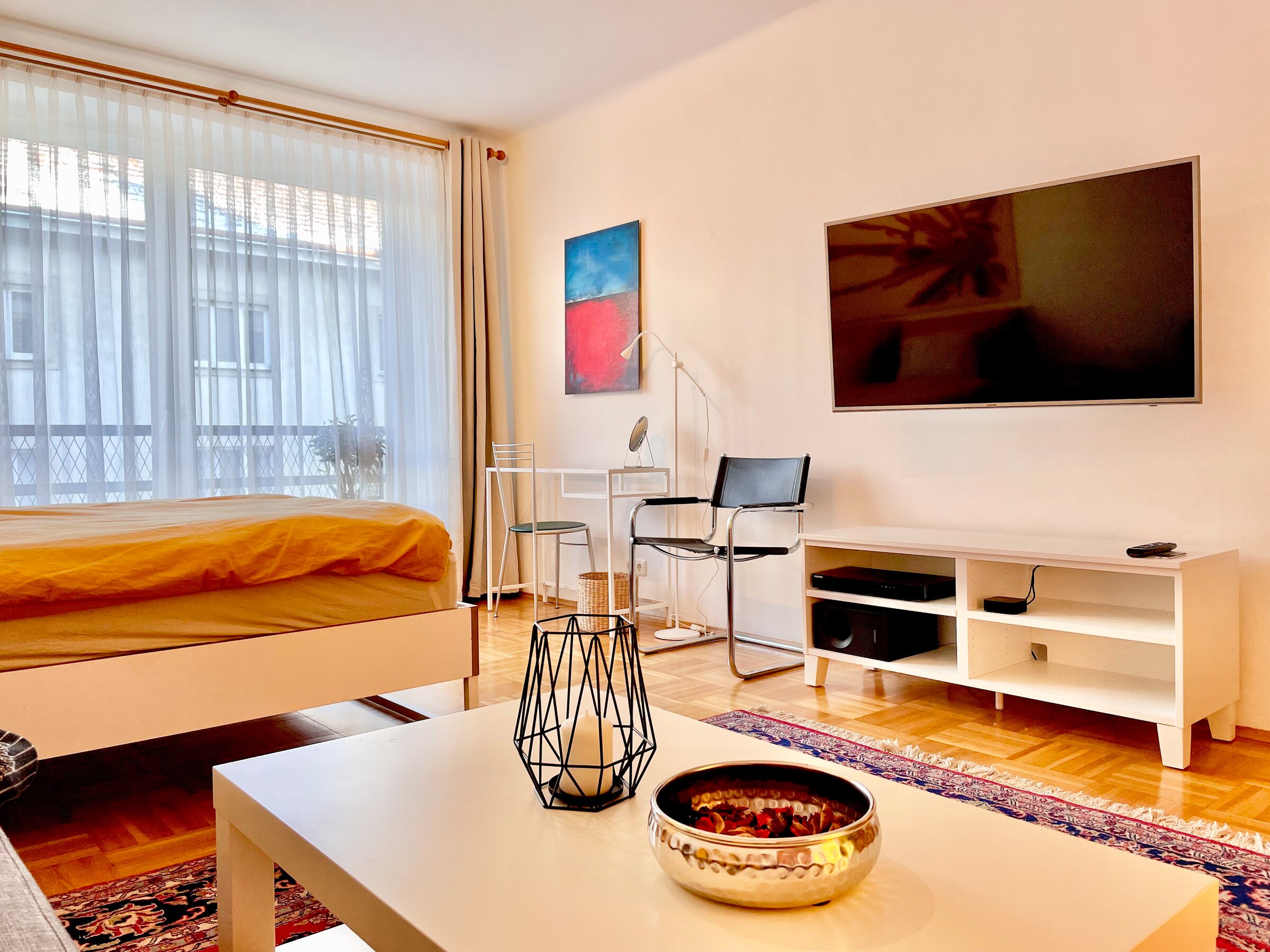 Gemeinsamer Wohn-/Schlafraum mit Flatscreen und kleinem Arbeitsplatz und gemütlicher Couch. | © rb