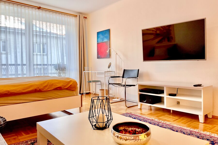 Gemeinsamer Wohn-/Schlafraum mit Flatscreen und kleinem Arbeitsplatz und gemütlicher Couch. | © rb