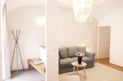 Helles Wohnzimmer mit Sofa & Rattanlampe – 2-Zimmer Wohnung zur Kurzzeitmiete, Wohnen auf Zeit für 1 bis 6 Monate in Wien