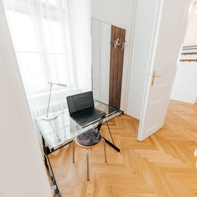 Bright workspace with glass desk & laptop – 3-room apartment for short-term rental & temporary housing for 1 to 6 months in Vienna