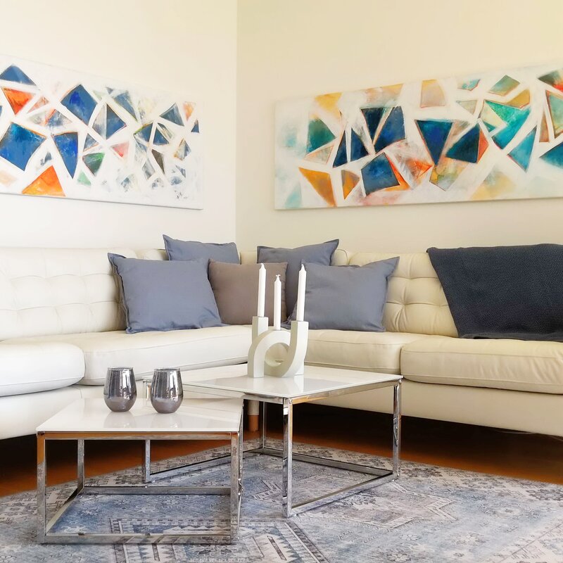 Helles Wohnzimmer mit Kunstwand & Ledersofa – 2-Zimmer Wohnung, Kurzzeitmiete Wien, Wohnen auf Zeit für 1 bis 6 Monate