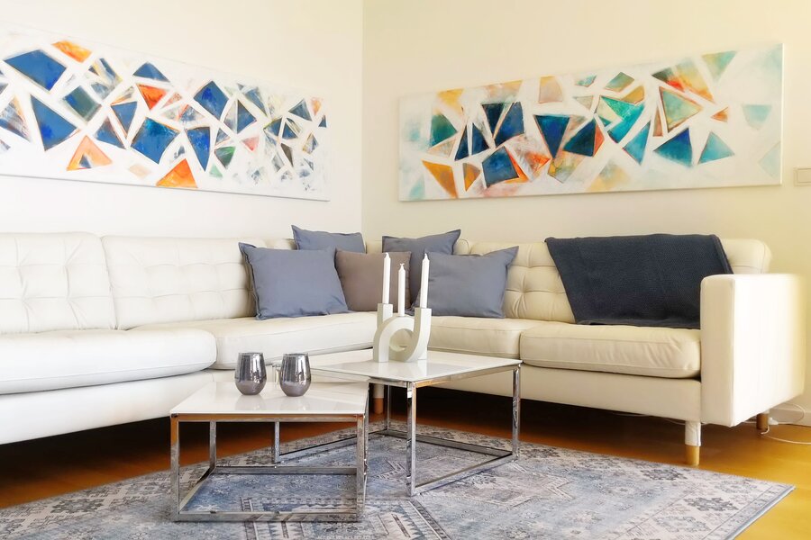 Helles Wohnzimmer mit Kunstwand & Ledersofa – 2-Zimmer Wohnung, Kurzzeitmiete Wien, Wohnen auf Zeit für 1 bis 6 Monate