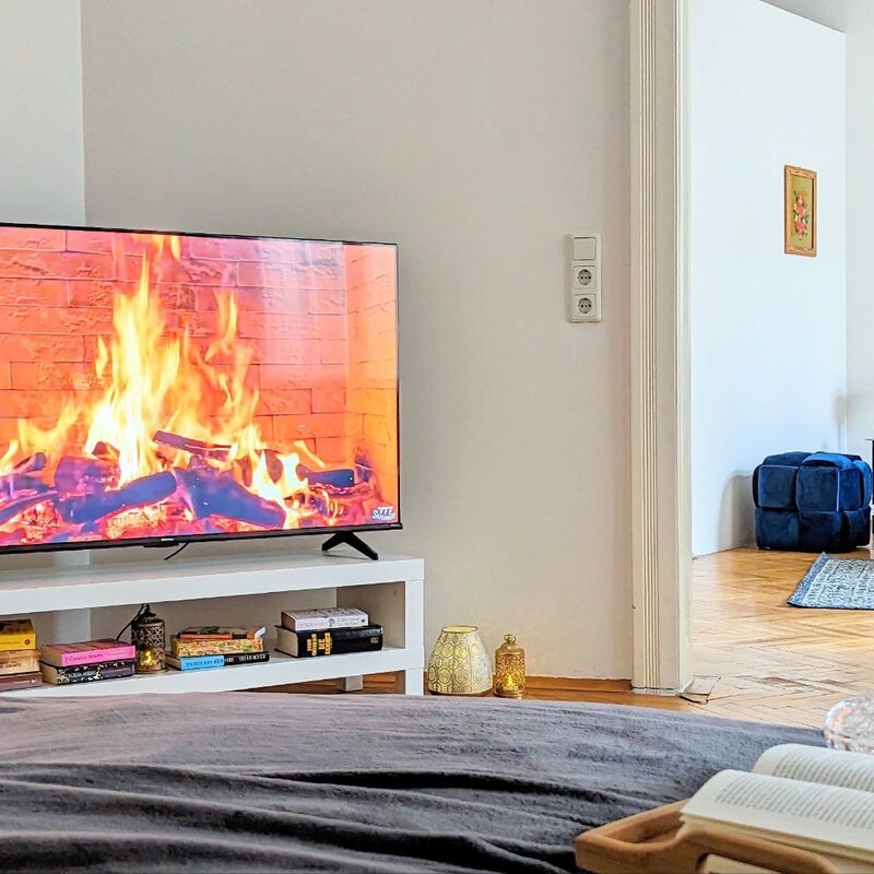 Helles Wohnzimmer mit TV-Kamin & Bücherregal – 2-Zimmer Wohnung zur Kurzzeitmiete & Wohnen auf Zeit für 1 bis 6 Monate in Wien