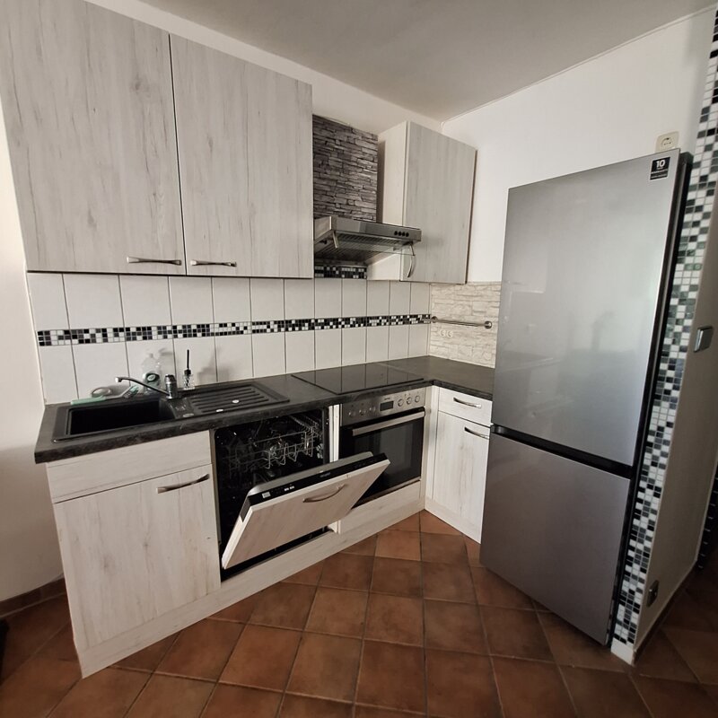 Küche mit Geschirrspüler, Herd, Ceranfeld und Kühlschrank