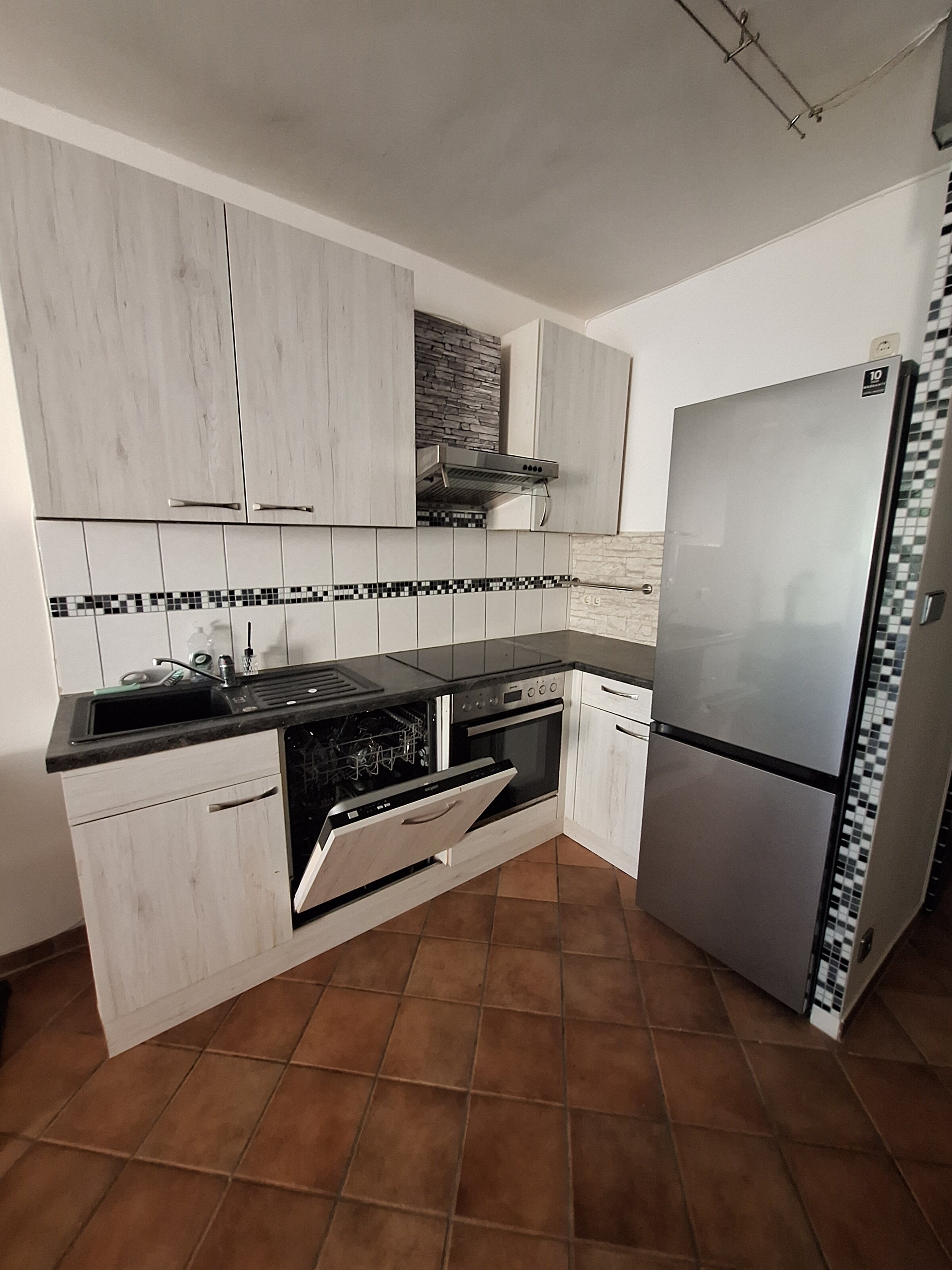 Küche mit Geschirrspüler, Herd, Ceranfeld und Kühlschrank