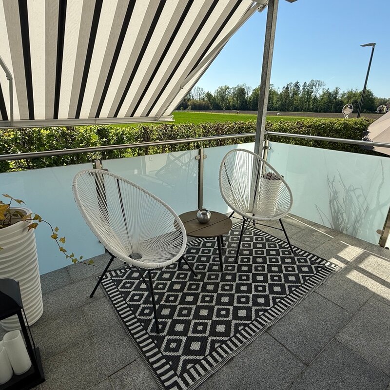Überdachte Terrasse mit Sonnenschutz und Garten