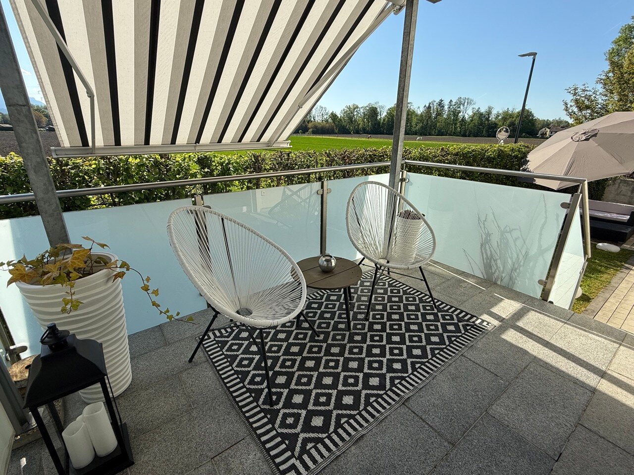 Überdachte Terrasse mit Sonnenschutz und Garten