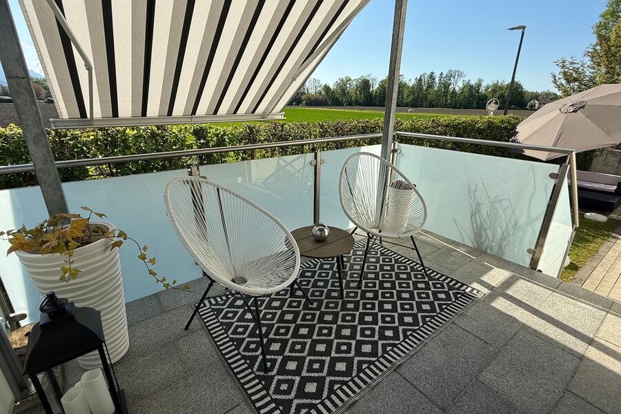 Überdachte Terrasse mit Sonnenschutz und Garten