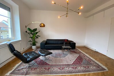 Helles Wohnzimmer mit Ledersofa & Orientteppich – 3-Zimmer Wohnung, Kurzzeitmiete Wien, Wohnen auf Zeit für 1 bis 6 Monate