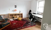 großes Arbeitszimmer mit Loungecke und Zugang zu Balkon mit Bergblick