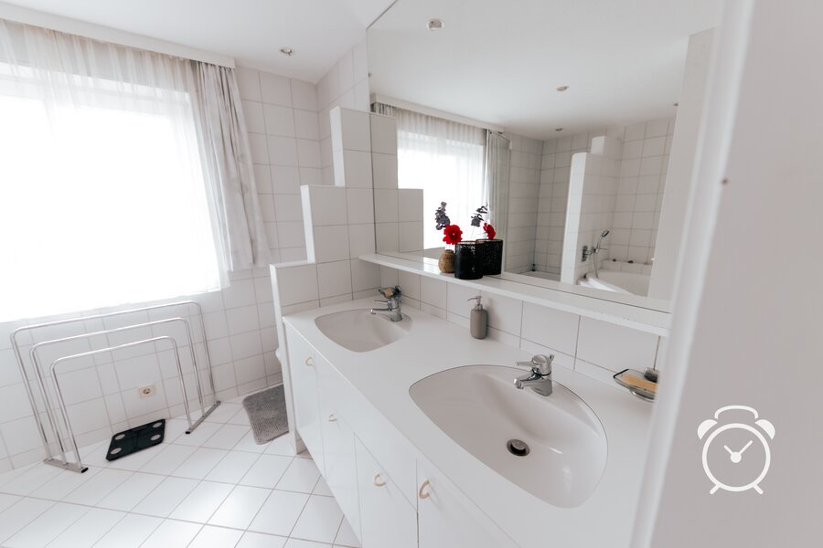 big bathroom with two sinks, big mirror, bathtub, shower and toilette