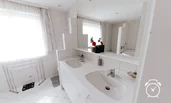 Badezimmer mit 2 Waschbecken, großem Spiegel, Badewanne, Dusche und WC