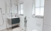 großes Badezimmer mit Regendusche, Waschbecken und Toilette