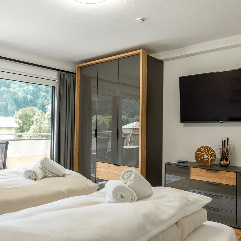 Bedroom with wardrobe, chest of drawers and flat-screen TV