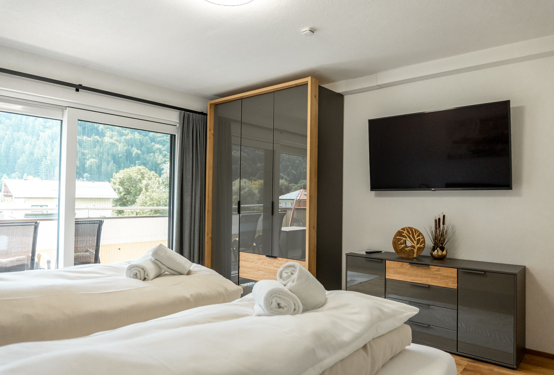 Bedroom with wardrobe, chest of drawers and flat-screen TV