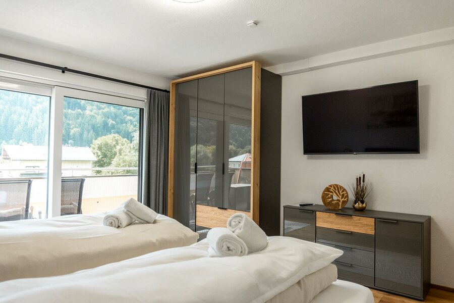 Schlafzimmer mit Kleiderschrank, Kommode und Flat-TV