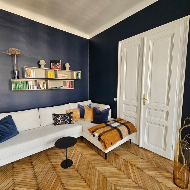 Bright living room with designer sofa & shelving – 2-room apartment for short-term rental & temporary housing for 1 to 6 months in Vienna