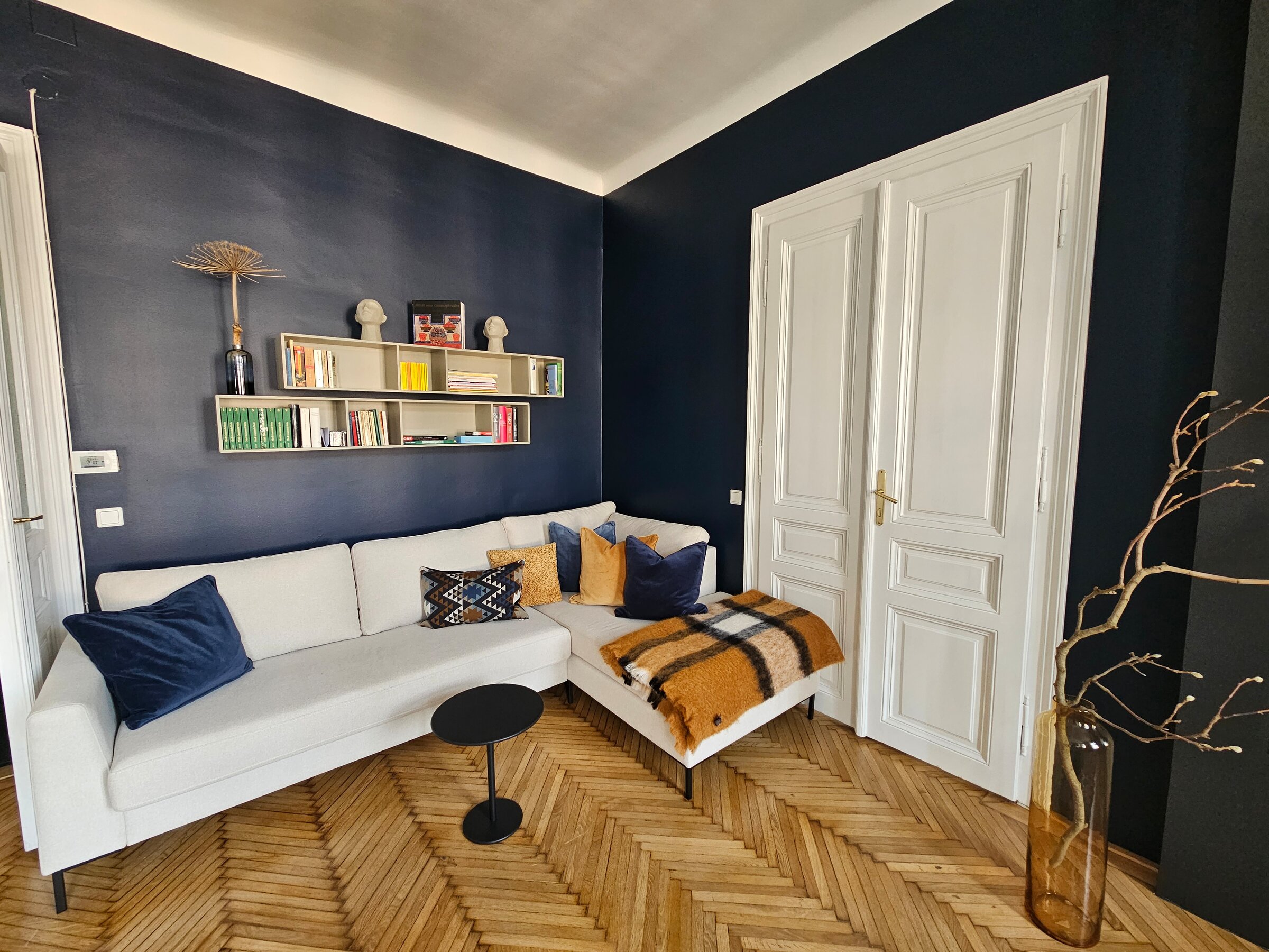 Bright living room with designer sofa & shelving – 2-room apartment for short-term rental & temporary housing for 1 to 6 months in Vienna