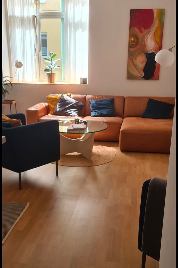 Bright living room with leather sofa & art wall – 2-room apartment, short-term rental, temporary housing 1 to 6 months, Vienna