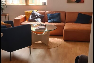 Bright living room with leather sofa & art wall – 2-room apartment, short-term rental, temporary housing 1 to 6 months, Vienna