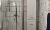 Badezimmer mit Dusche und Kasten