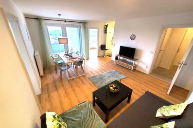 Helles Wohnzimmer mit Holzboden & Balkon – 3-Zimmer Wohnung zur Kurzzeitmiete, Wohnen auf Zeit 1–6 Monate, Traun
