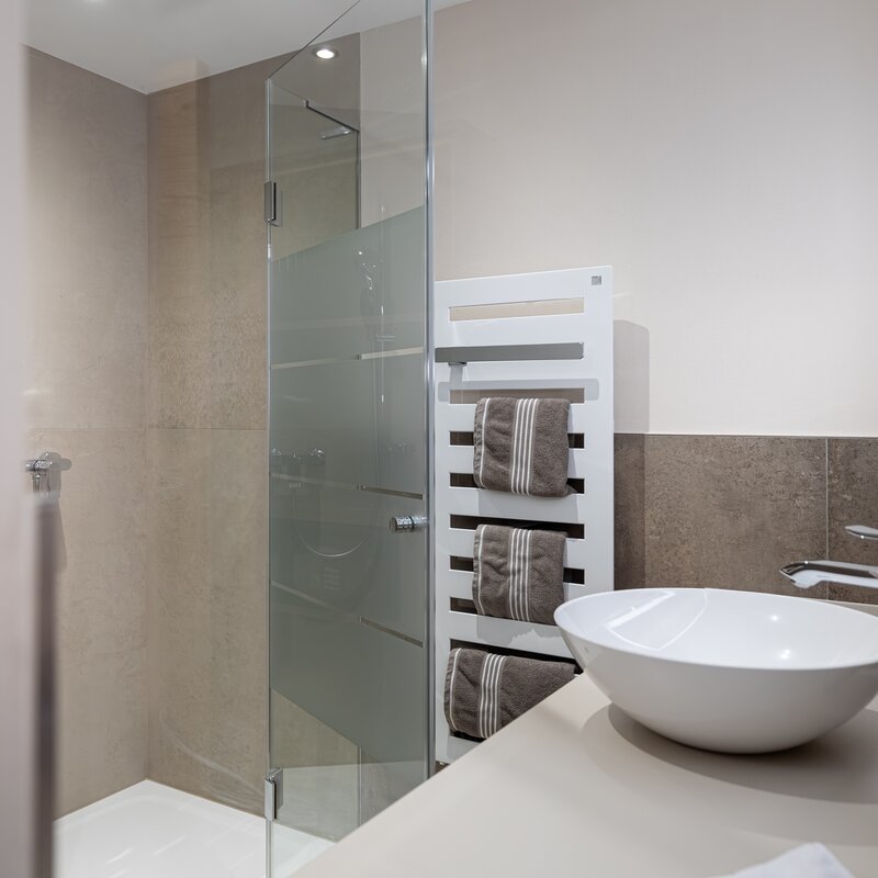 Modern bathroom with glass shower & towel radiator – 1-room apartment, short-term rental Salzburg, temporary housing for 1 to 6 months