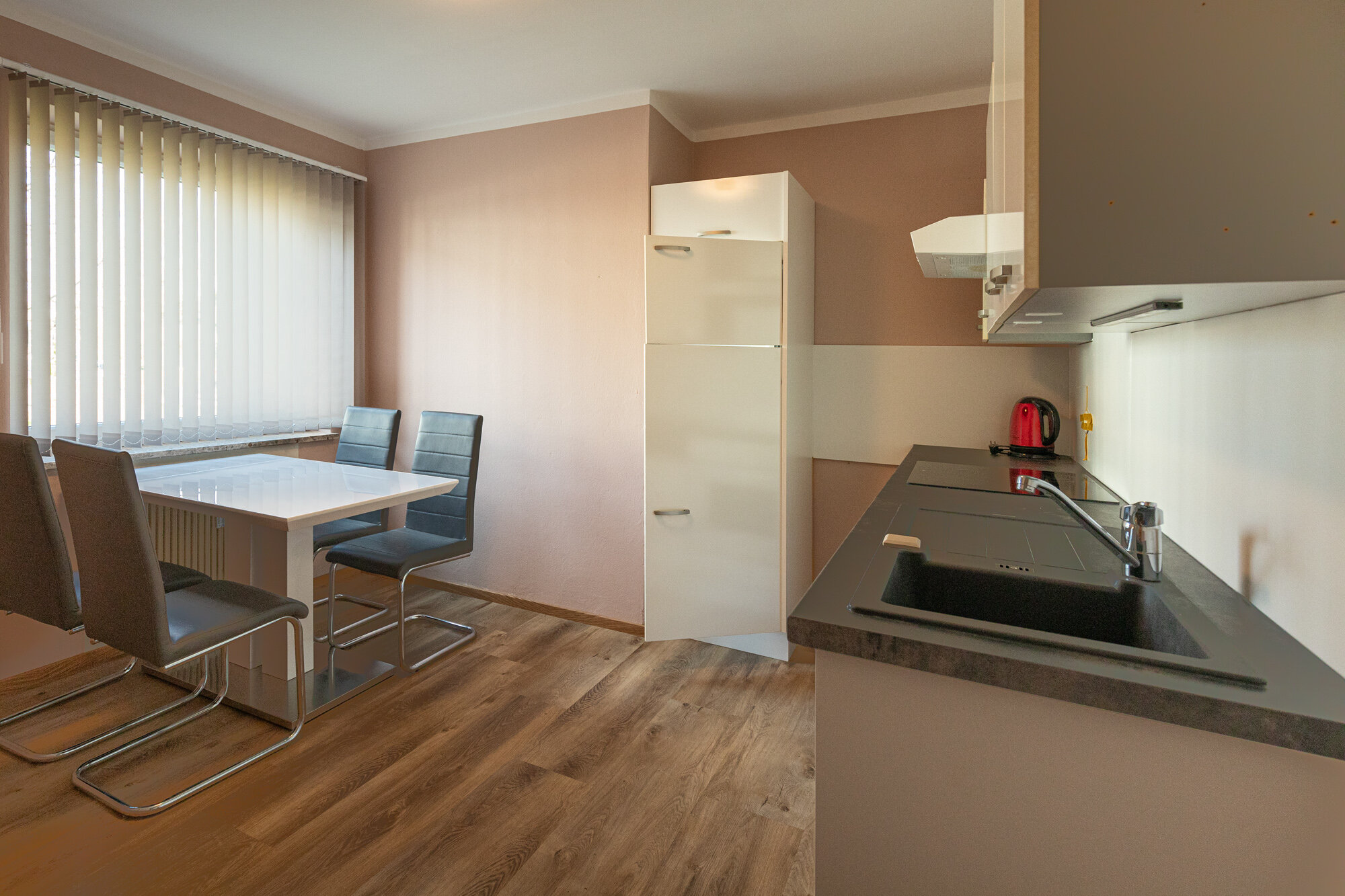 mit Esstisch, Kühlschrank, Ofden, Herd, Wasserkocher sowie Bessteck, Teller und Gläser