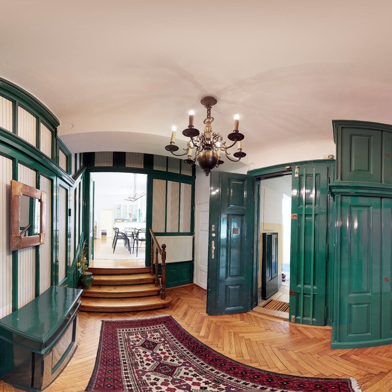 Eleganter Altbau-Eingangsbereich mit grünen Holzvertäfelungen – 4-Zimmer Wohnung zur Kurzzeitmiete in Wien