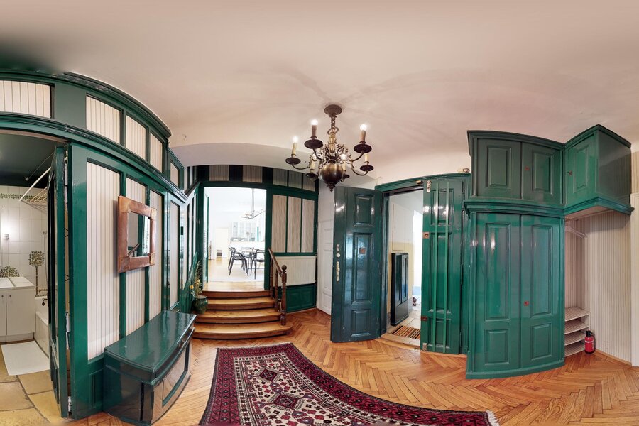 Eleganter Altbau-Eingangsbereich mit grünen Holzvertäfelungen – 4-Zimmer Wohnung zur Kurzzeitmiete in Wien