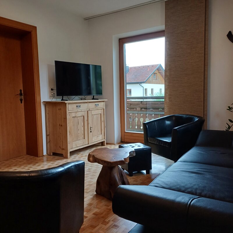 Wohnzimmer mit Ledersofa & TV – 3-Zimmer-Wohnung zur Kurzzeitmiete & Wohnen auf Zeit für 1 bis 6 Monate in Grödig