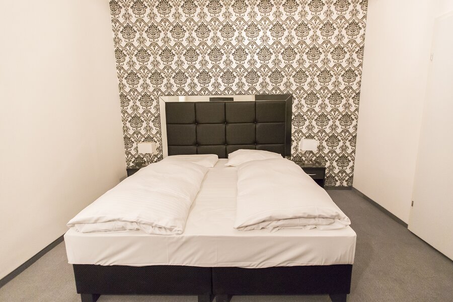 Neat double bed with white linen – 2-room apartment, short-term rental & temporary housing for 1 to 6 months in Vienna