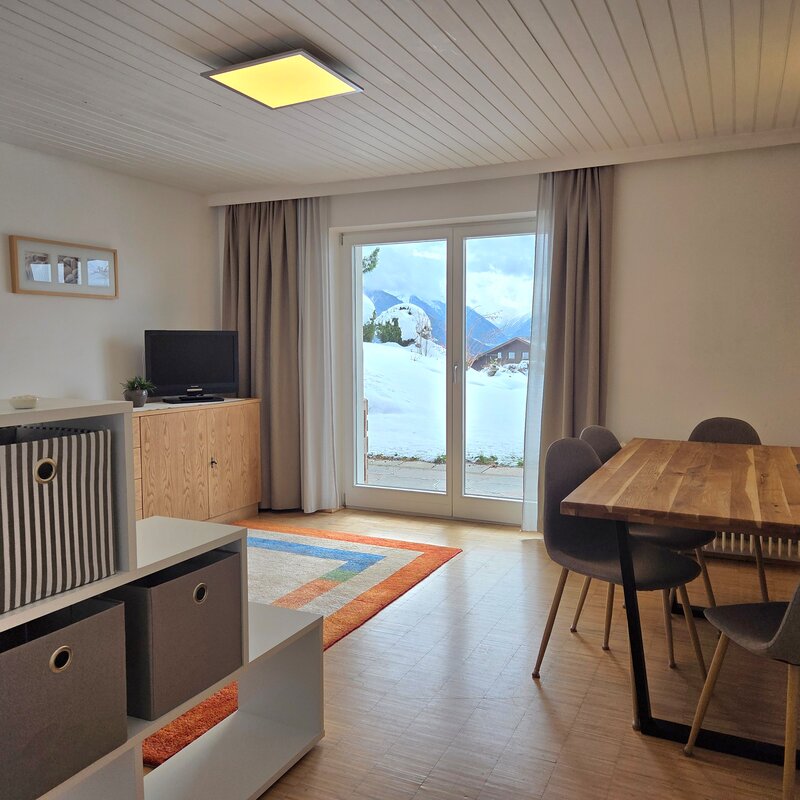 Helles Wohnzimmer mit Holztisch & Bergpanorama – 2-Zimmer Apartment, Kurzzeitmiete Patsch, Wohnen auf Zeit für 1 bis 6 Monate