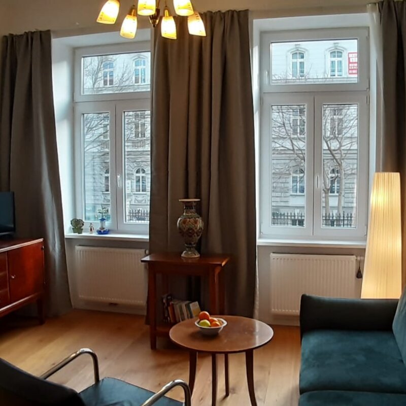 Bright living room with parquet & period windows – 2-room apartment, short-term rental Vienna, temporary housing for 1 to 6 months
