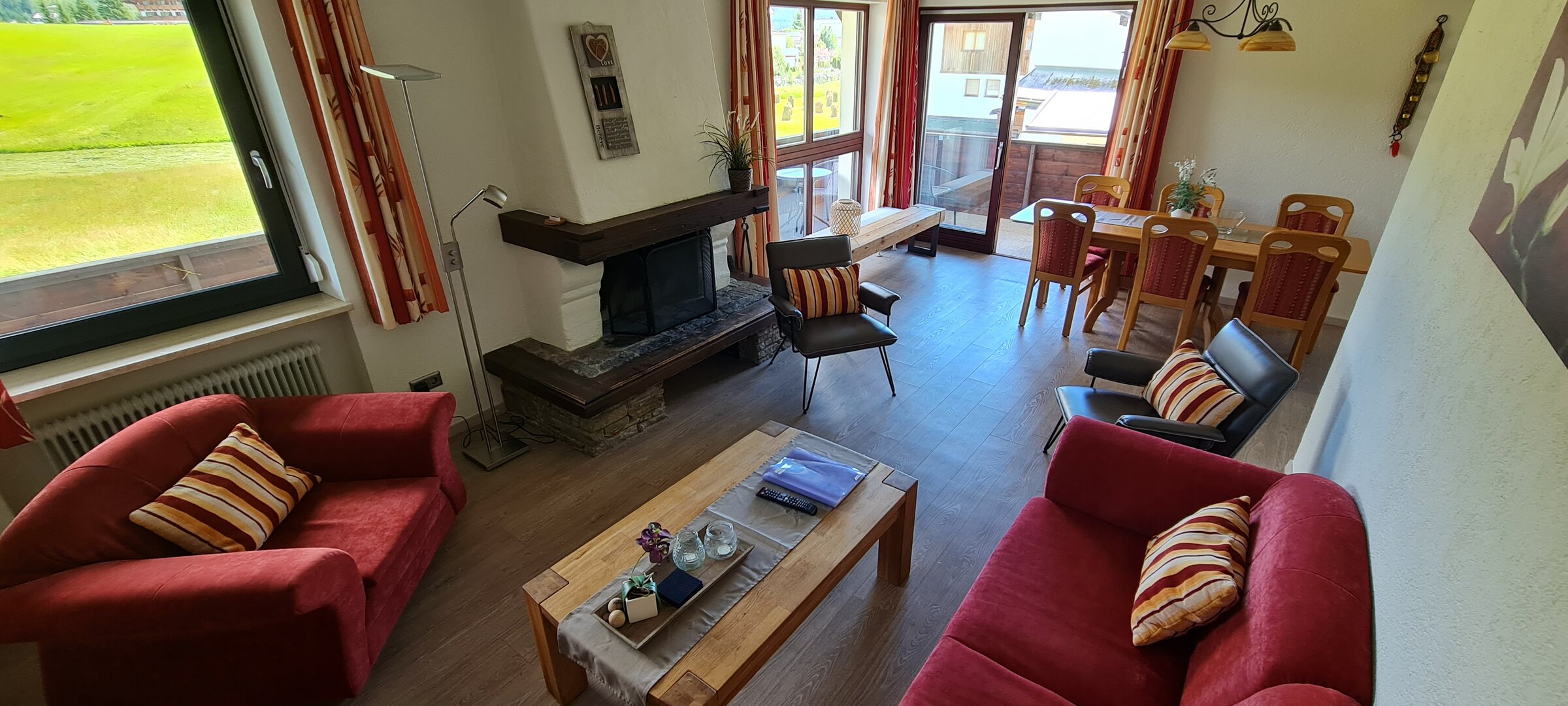 Wohnzimmer mit offenen Kamin und zugang zum Balkon | © Kazza