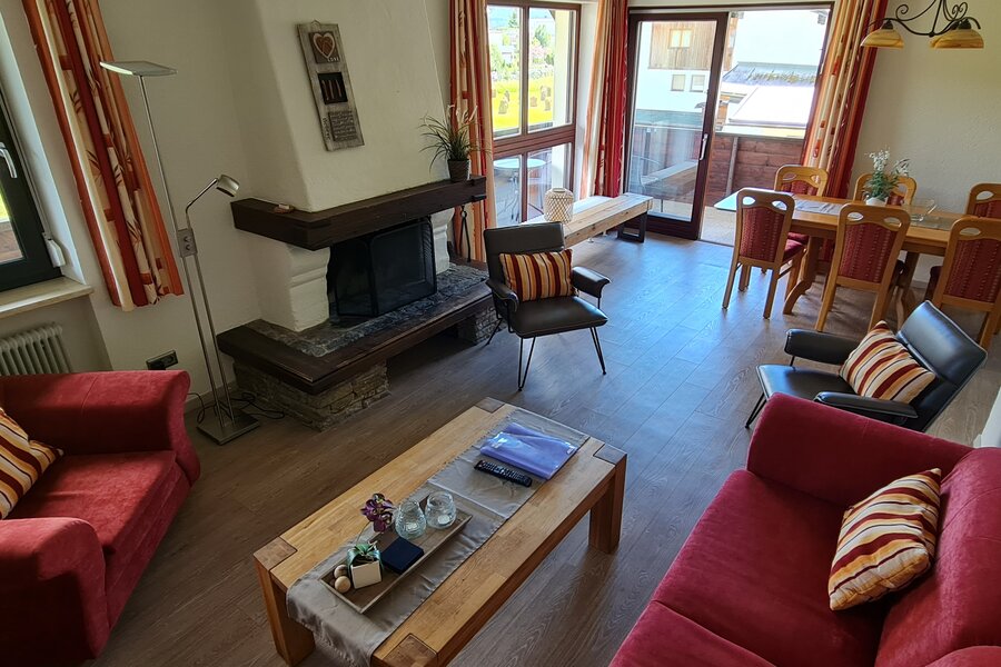 Wohnzimmer mit offenen Kamin und zugang zum Balkon | © Kazza