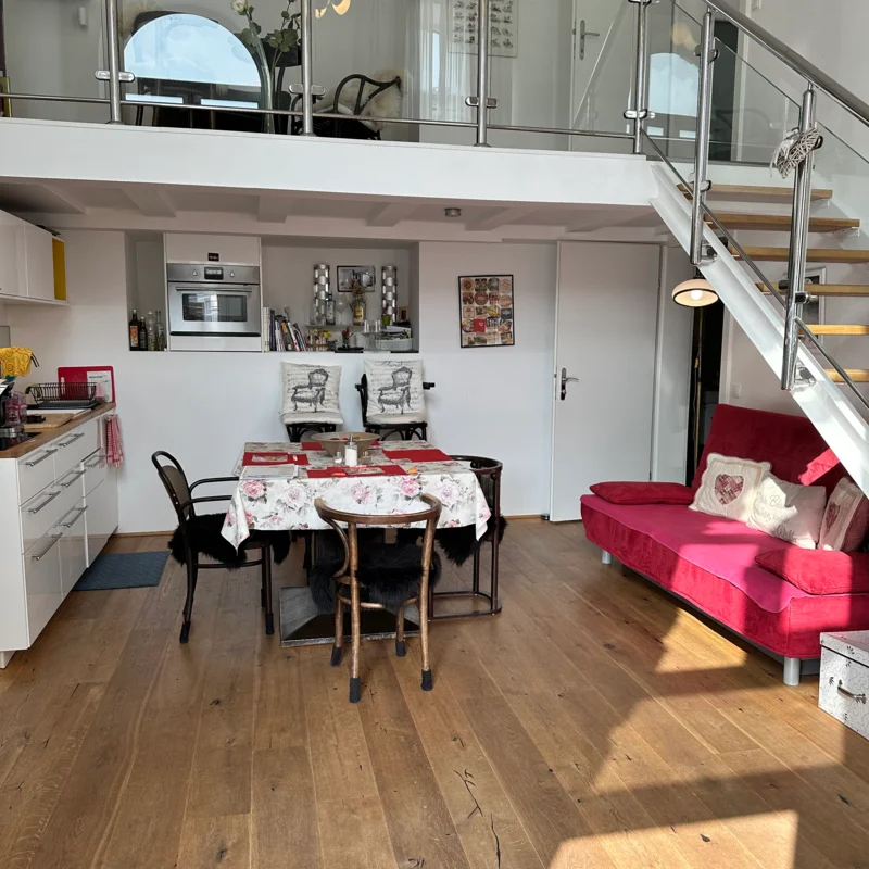 Man sieht die Wohnküche inklusive Sofa und Esstisch