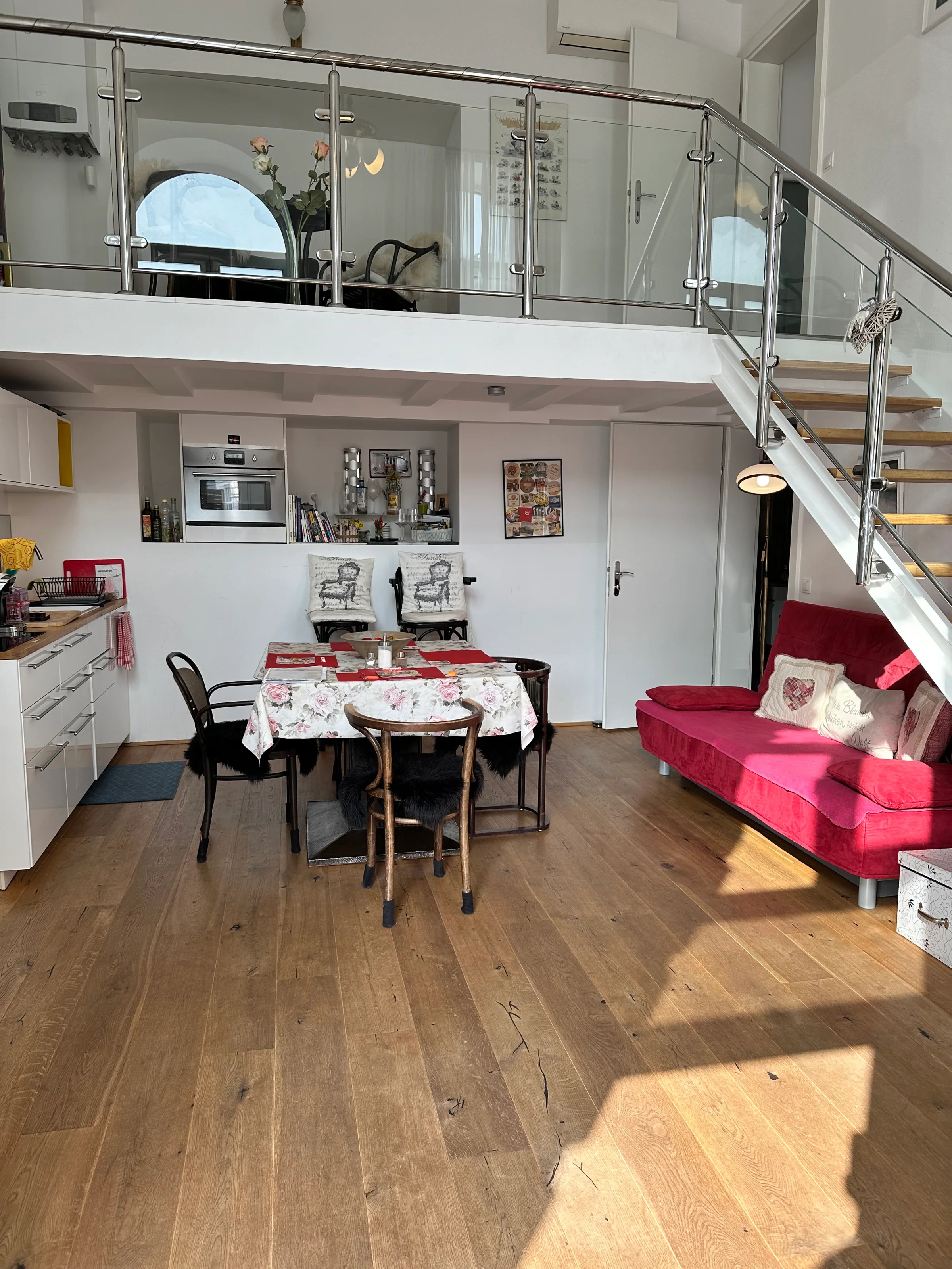 Man sieht die Wohnküche inklusive Sofa und Esstisch