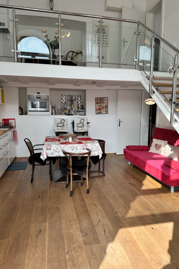 Man sieht die Wohnküche inklusive Sofa und Esstisch