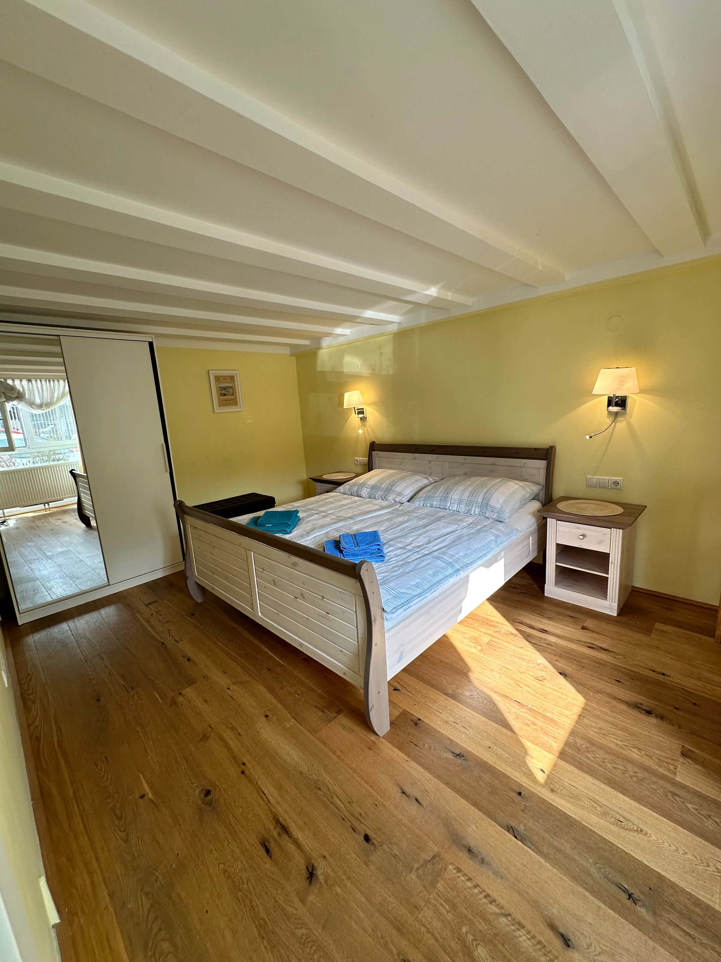 Das Schlafzimmer ist ausgestattet mit einem 2m x 1,80m Bett, einem Kasten mit Spiegel und Nachttischen