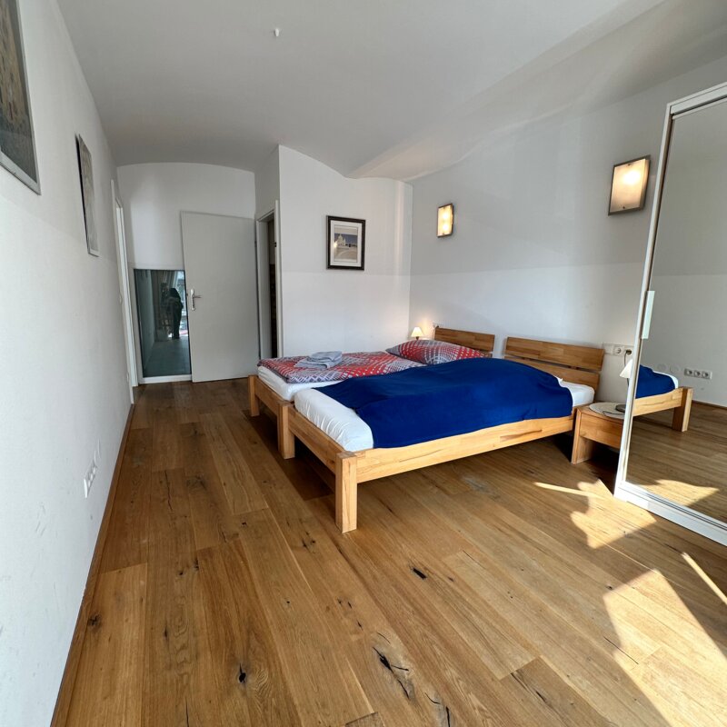 Schlafzimmer mit zwei Einzelbetten, Kasten mit Spiegel,  Nachttischen und einem eigenen WC
