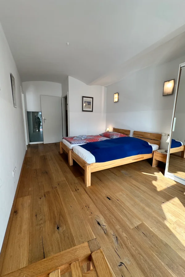 Schlafzimmer mit zwei Einzelbetten, Kasten mit Spiegel,  Nachttischen und einem eigenen WC