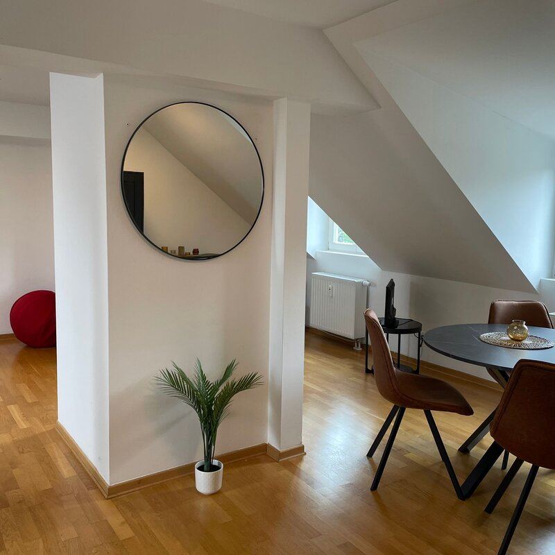 Bright living area with sloped ceiling & wood floor – 1-room apartment, short-term rental & temporary housing for 1 to 6 months in Salzburg